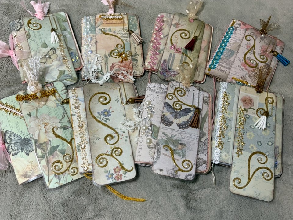 Handmade vintage-style journals decorated with florals, butterflies, and gold glitter swirls